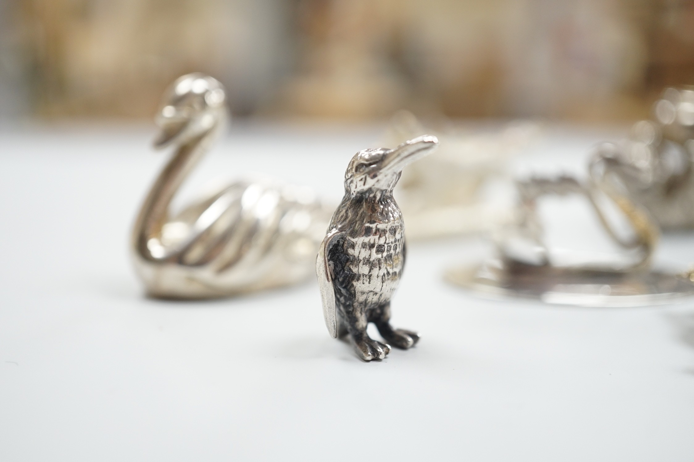 Eight assorted modern silver miniature animal or bird figures including menu holders, including rabbit by Tessiers Ltd, height 27mm, an earlier silver swan menu holder and a silver gilt owl brooch.